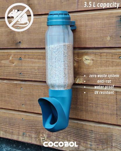 Mangeoire Cocobol pour poules avec réservoir translucide, niveau de grain visible, installation extérieure sur bois